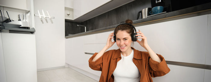 Side view of young woman using mobile phone in office