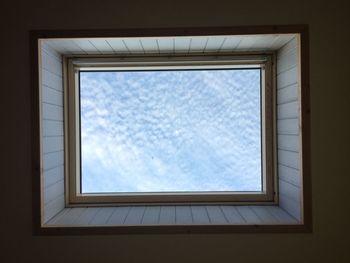 Directly below shot of skylight against cloudy sky