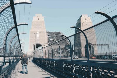 Bridge by buildings against sky in city