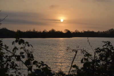 Scenic view of lake against orange sky