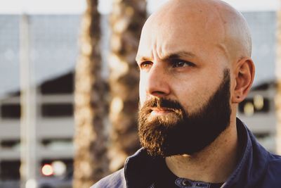 Close-up of thoughtful bald man looking away outdoors