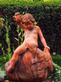 Statue of man standing by plants