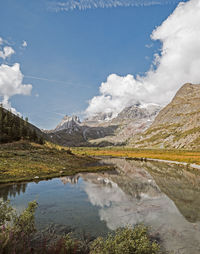 Scenic view of lake by mountains against sky