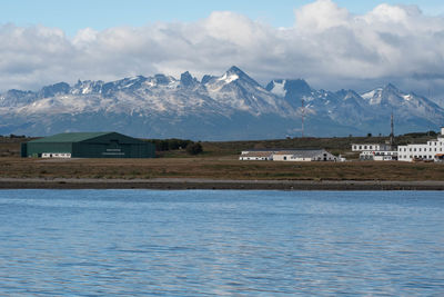 Scenic view of lake by snowcapped mountains against sky