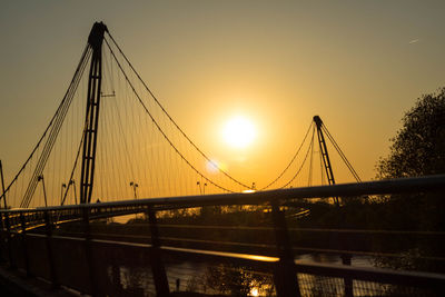 Suspension bridge against sky during sunset