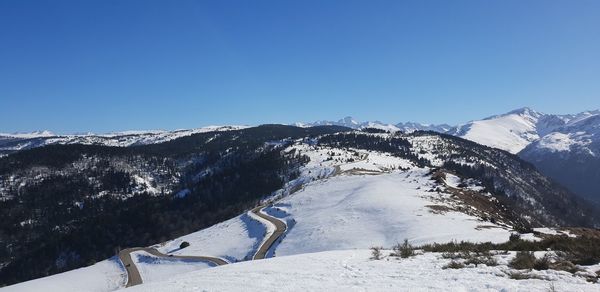 Scenic view of snowcapped mountains against clear blue sky