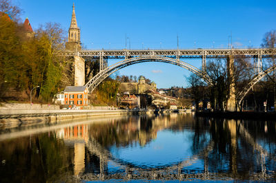 Bridge over river in city against sky