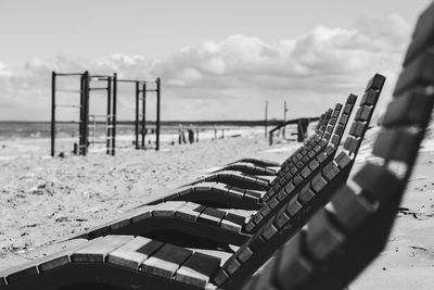 Low section of man standing by railing against sky