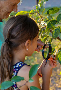 Close-up of woman holding magnifying glass