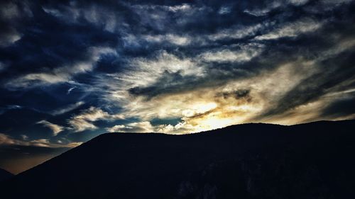 Scenic view of mountains against cloudy sky