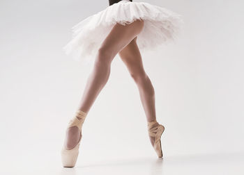 A photo of a ballerina's legs in pointes showing a pa during a performance