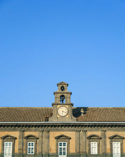 Low angle view of clock tower against clear blue sky