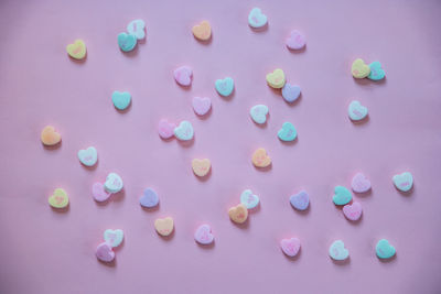 Directly above shot of heart shapes on pink background