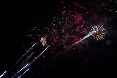 Low angle view of firework display at night