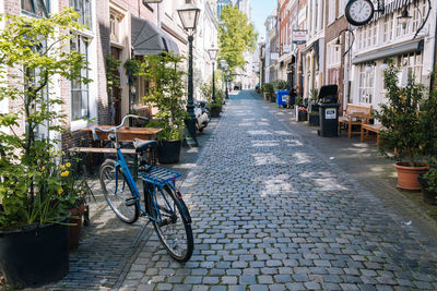 Bicycles parked on street amidst buildings in city