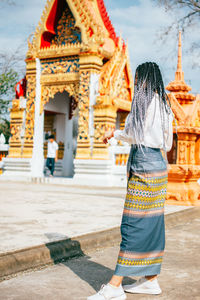 Rear view of woman against temple building