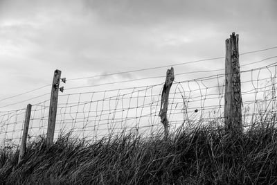 Fence on field against sky