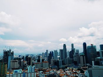 Aerial view of buildings in city against sky