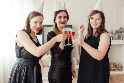 Portrait of smiling woman with friends celebrating at home