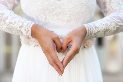 Midsection of woman with forming heart shape