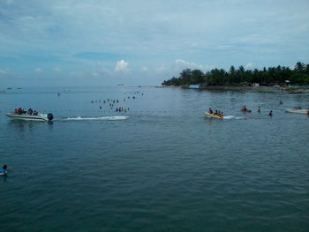 People on sea against sky