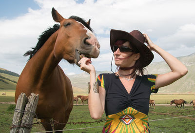 Woman feeding horse at ranch