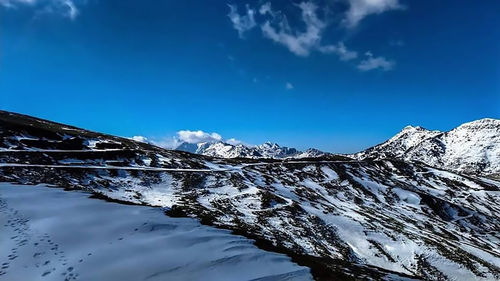 Snow covered mountain against blue sky