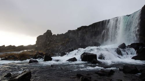 Scenic view of waterfall against sky