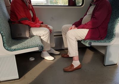 Low section of people sitting in train