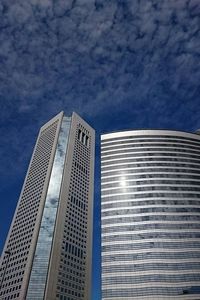 Low angle view of modern building against cloudy sky