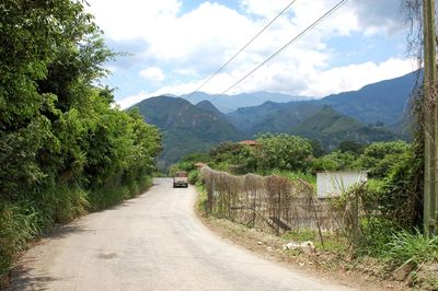 Road by mountain against sky