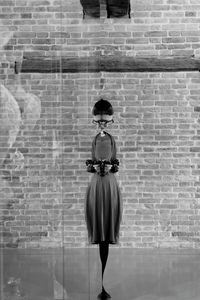 Man standing against brick wall