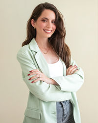 Portrait of young woman standing against white background