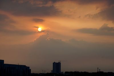 Silhouette cityscape against sky during sunset