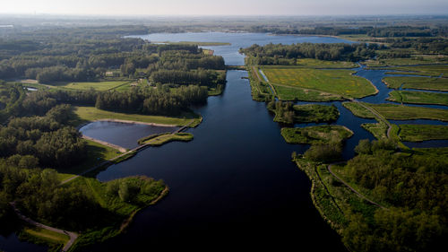 High angle view of river amidst trees against sky