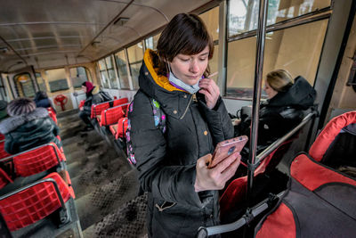 Full length of man using mobile phone at train