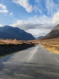 Road by mountain against sky