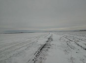 Scenic view of snow covered land against sky