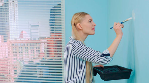 Side view of young woman using mobile phone