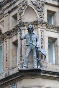 Low angle view of statue against historic building