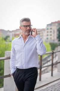 Man using mobile phone standing outdoors