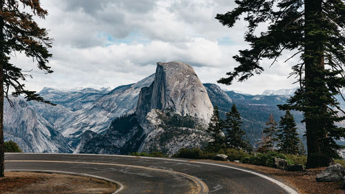 Road by mountains against sky