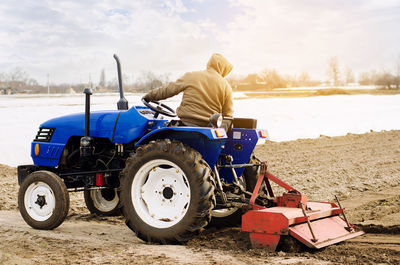 Farmer on a tractor with milling machine loosens, grinds and mixes soil. loosening the surface