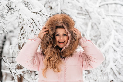 Portrait of happy woman standing in snow