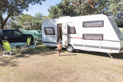 Two caucasian children play and spend alternative holidays in a caravan