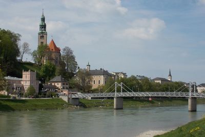 Bridge over river against buildings in city