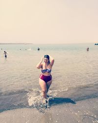 Full length of woman on beach against clear sky