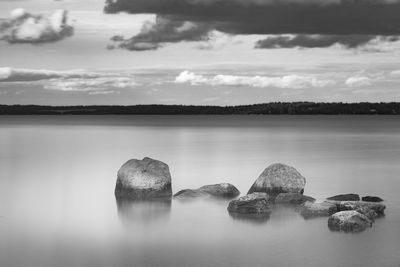 Rocks in sea against sky
