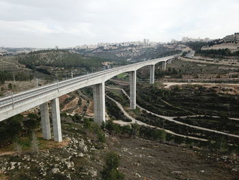 Bridge over road against sky in city