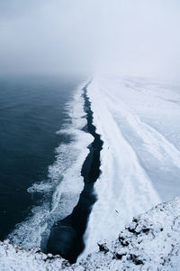 Close-up of snow on sea against sky